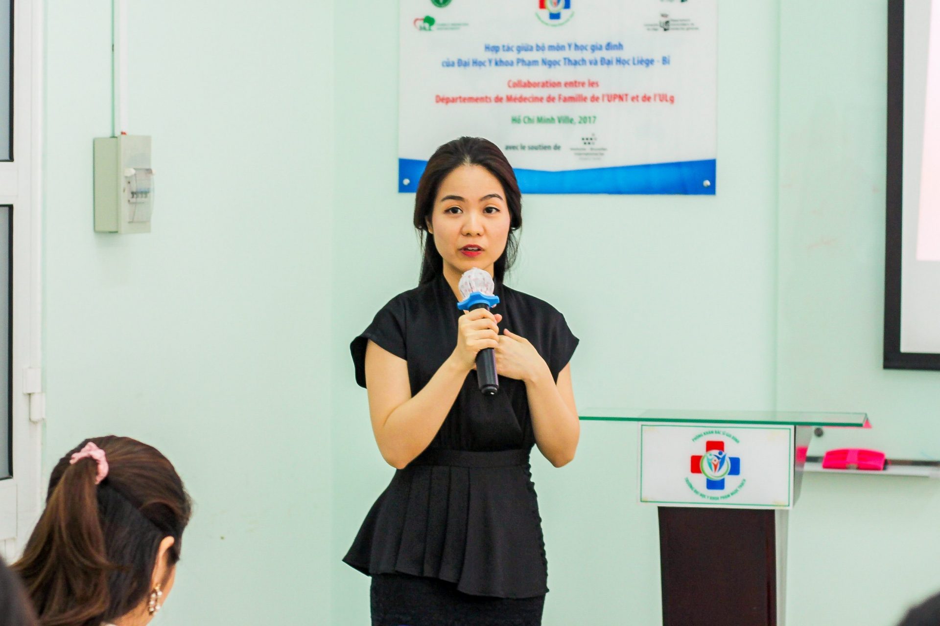 A person speaking into a microphone
Description automatically generated